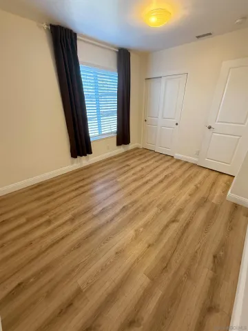 an empty room with wooden floor and closet