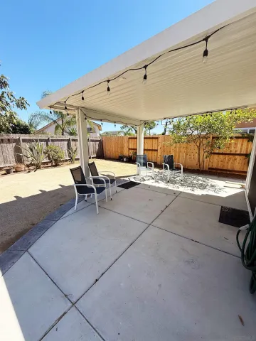 a view of a patio with a table and chairs under an umbrella
