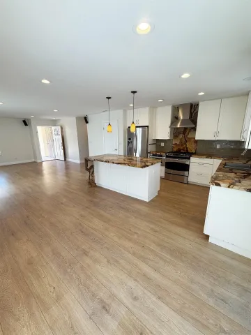a view of kitchen with kitchen island microwave and cabinets