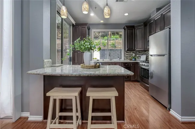 a kitchen with kitchen island a counter top space a sink stainless steel appliances and cabinets