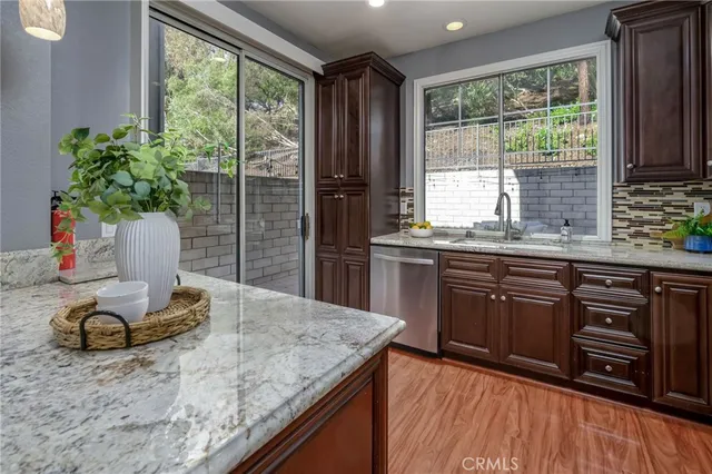 a kitchen with granite countertop sink stove and cabinets
