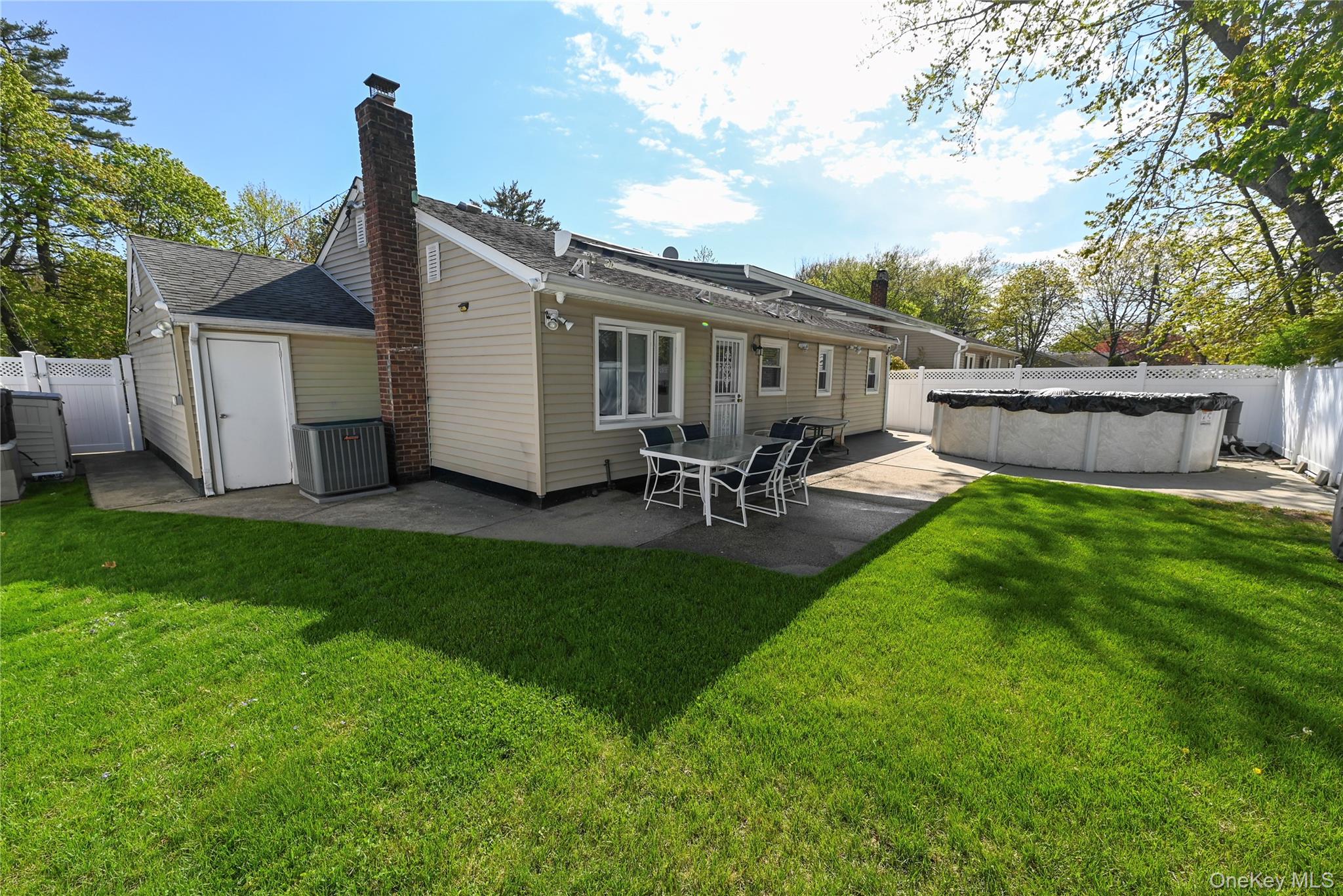 1522 Rica Place Valley Stream, NY 11580 - Photo 23 of 34 a view of a backyard with table and chairs potted plants and large tree