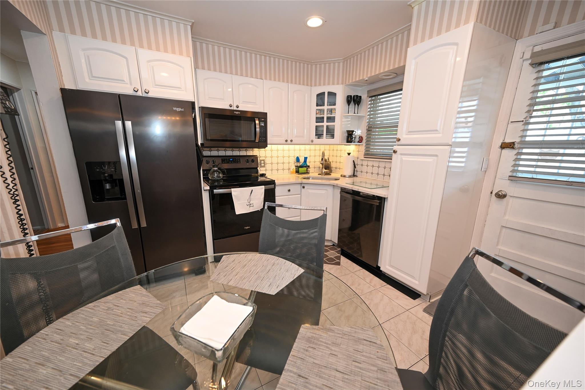 1522 Rica Place Valley Stream, NY 11580 - Photo 6 of 34 a kitchen with stainless steel appliances a refrigerator a stove a sink dishwasher and a dining table with wooden floor