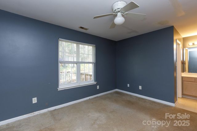 an empty room with windows and ceiling fan