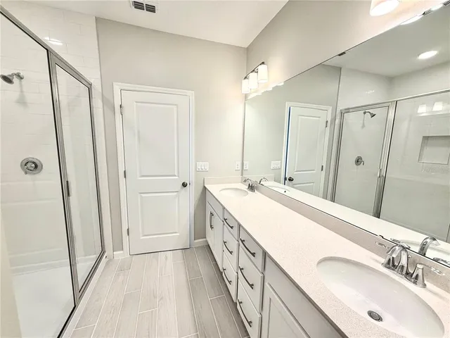 a bathroom with double sink and a mirror