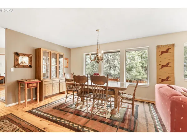 a living room with furniture large window and wooden floor