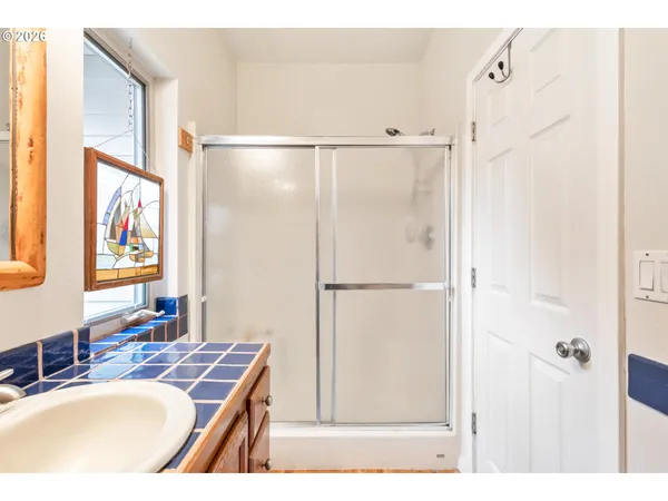 a bathroom with a granite countertop shower sink vanity and a mirror