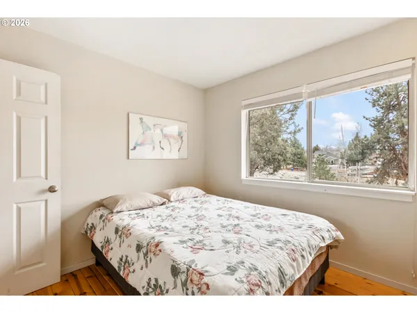 a bedroom with a bed and a large window