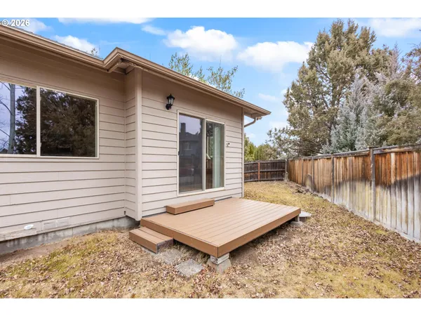 a backyard of a house with a table and chairs