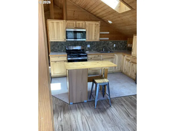 a kitchen with a sink cabinets and wooden floor