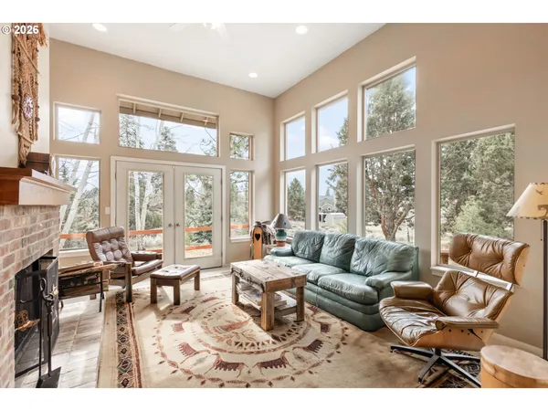 a living room with furniture and floor to ceiling windows