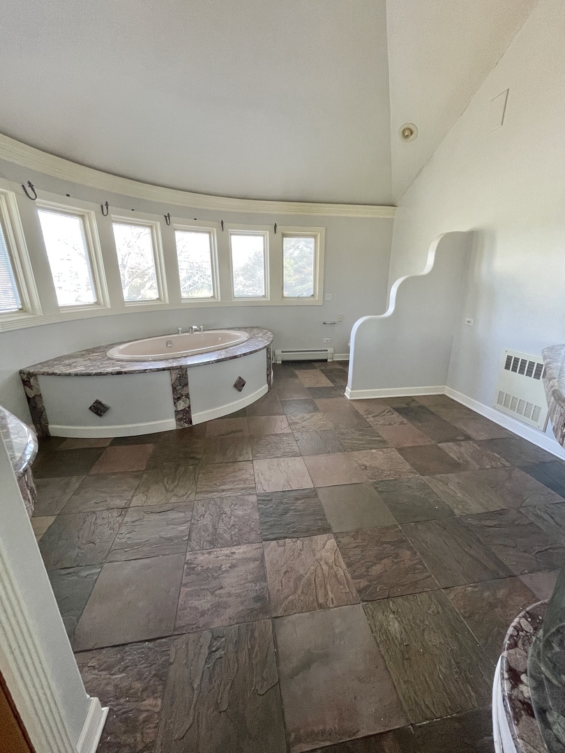 990 Stonehedge Drive Addison, IL 60101 - Photo 16 of 18 a spacious bathroom with a tub and mirror