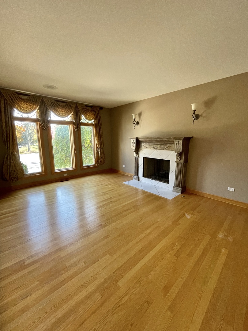 990 Stonehedge Drive Addison, IL 60101 - Photo 4 of 18 an empty room with wooden floor and windows