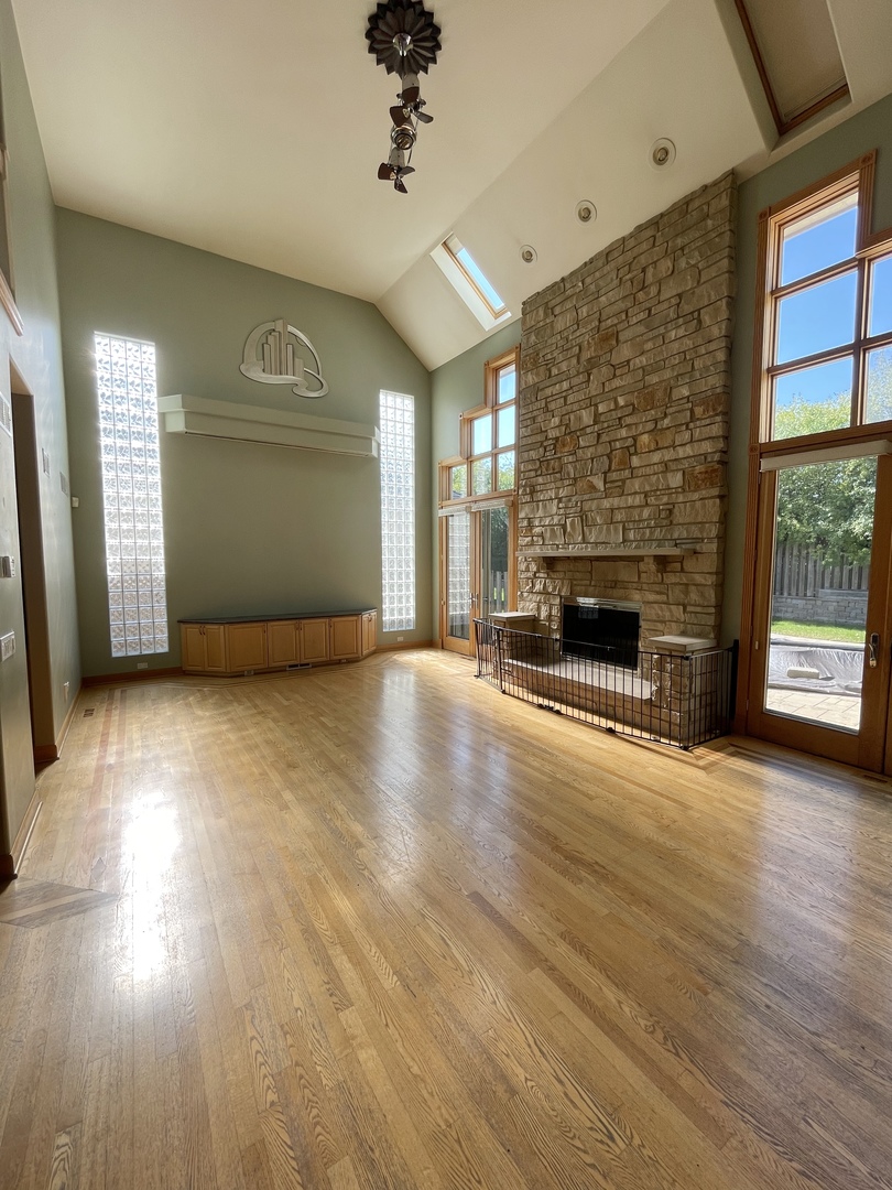 990 Stonehedge Drive Addison, IL 60101 - Photo 5 of 18 an empty room with wooden floor fireplace and windows