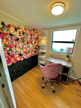 a view of a workspace with furniture and a wooden floor