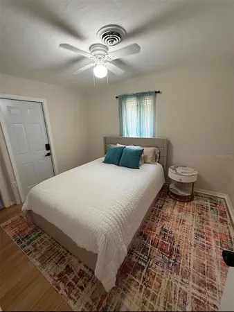 a bedroom with a bed and a lamp on dresser