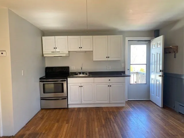 a kitchen with granite countertop white cabinets and stainless steel appliances