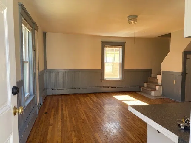 a view of a room with wooden floor and a window