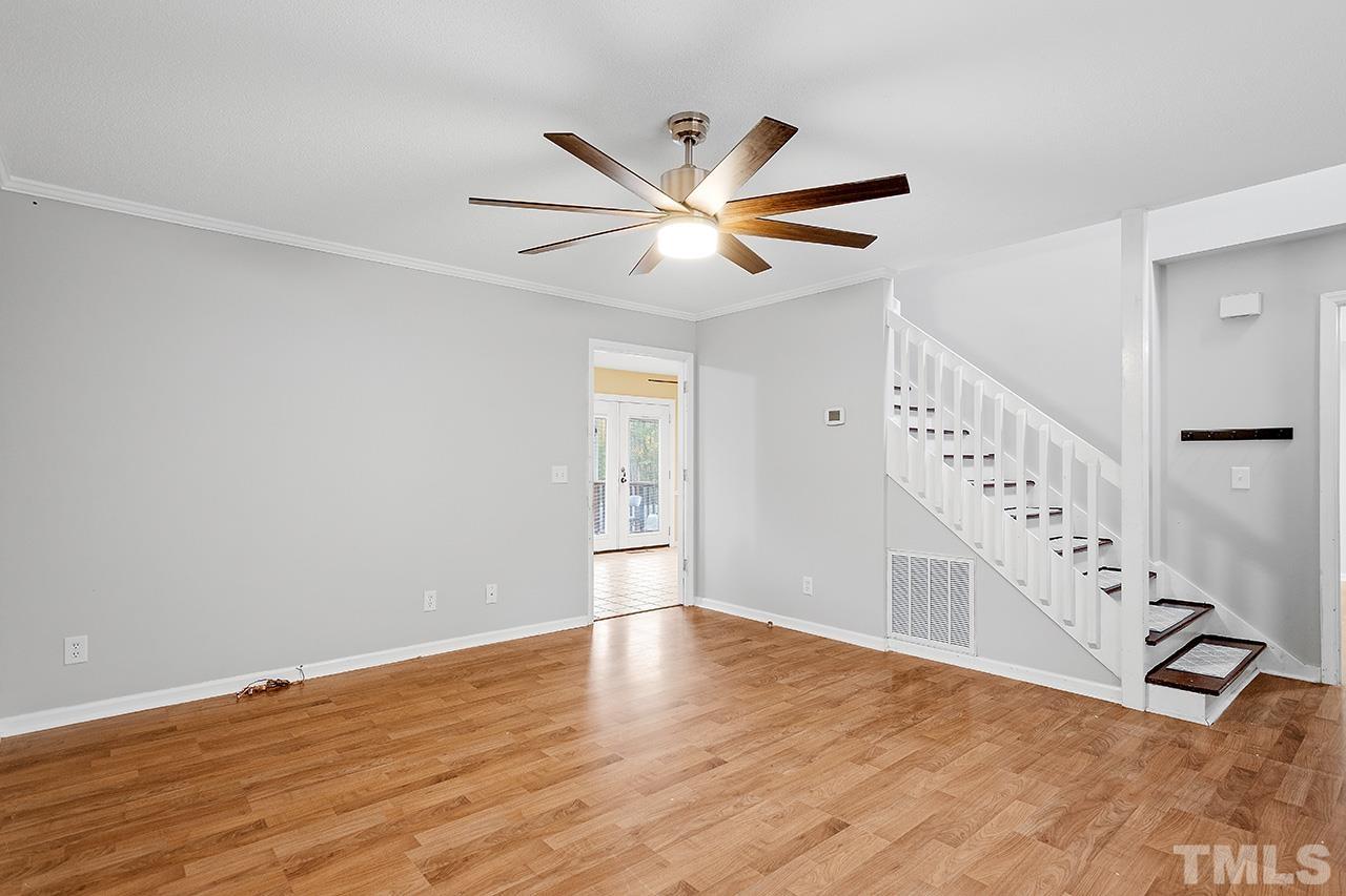 53 Phil Johnson Road Sanford, NC 27330 - Photo 5 of 29 a view of an empty room with wooden floor and a ceiling fan