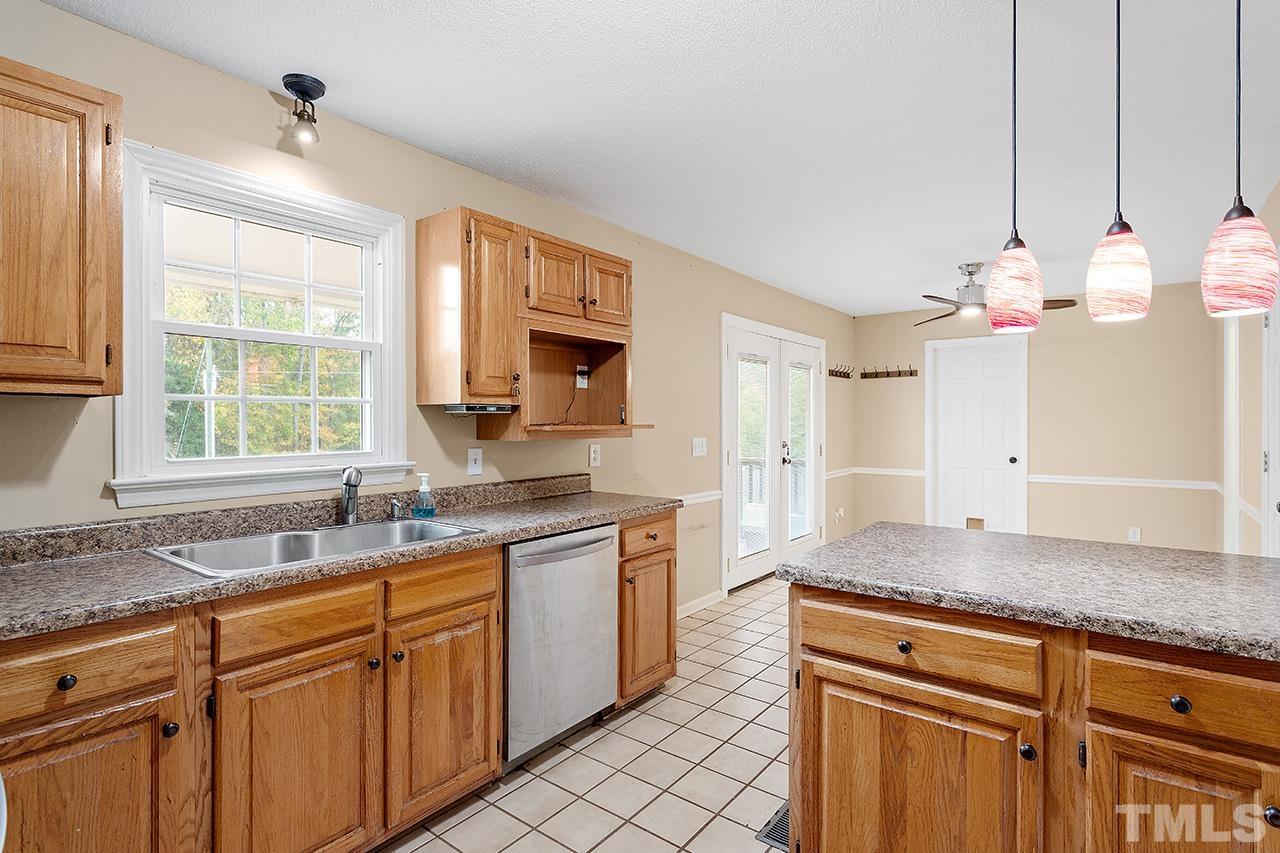 53 Phil Johnson Road Sanford, NC 27330 - Photo 8 of 29 a kitchen with stainless steel appliances granite countertop a sink dishwasher and white cabinets with wooden floor