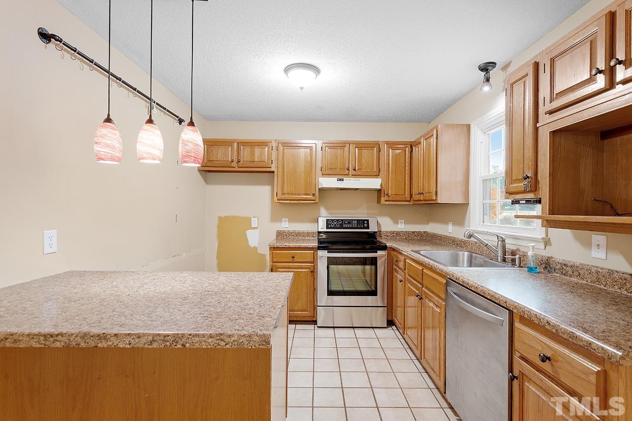 53 Phil Johnson Road Sanford, NC 27330 - Photo 9 of 29 a kitchen with stainless steel appliances granite countertop a sink stove and refrigerator