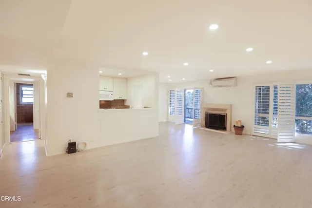 a view of empty room with wooden floor and fireplace