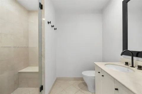 a bathroom with a granite countertop toilet a sink and a mirror