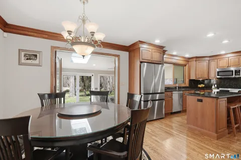 a view of a dining room with furniture a chandelier and wooden floor