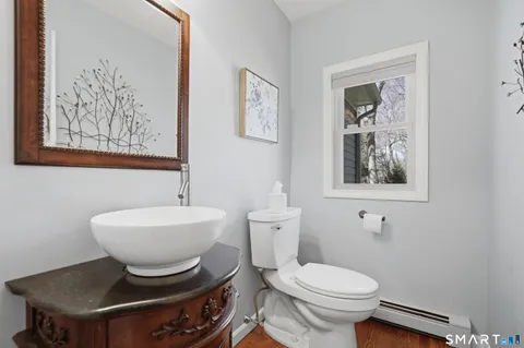 a bathroom with a toilet a sink and mirror