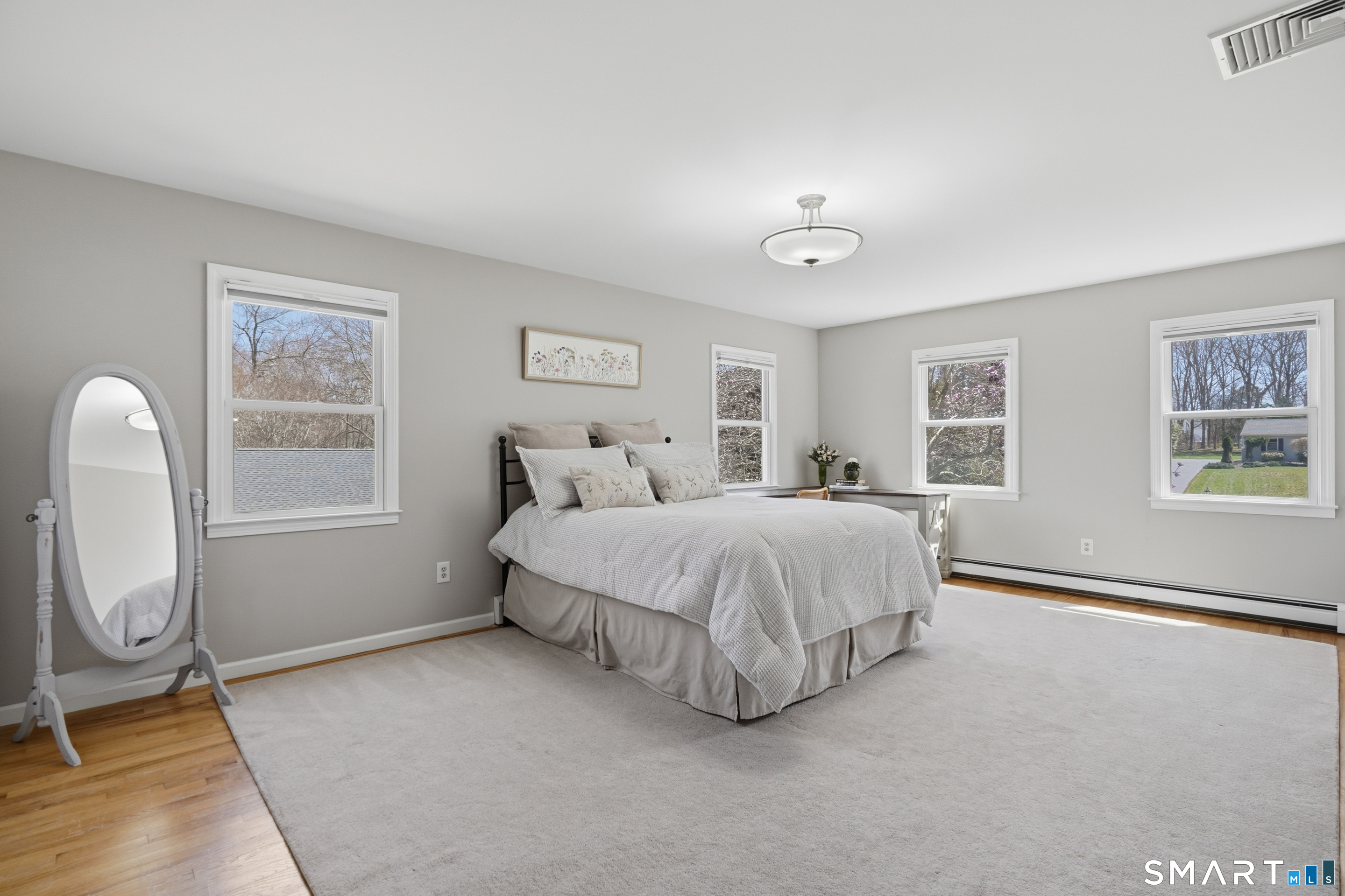 21 Shawnee Lane Monroe, CT 06468 - Photo 30 of 43 a spacious bedroom with a bed a table and painting