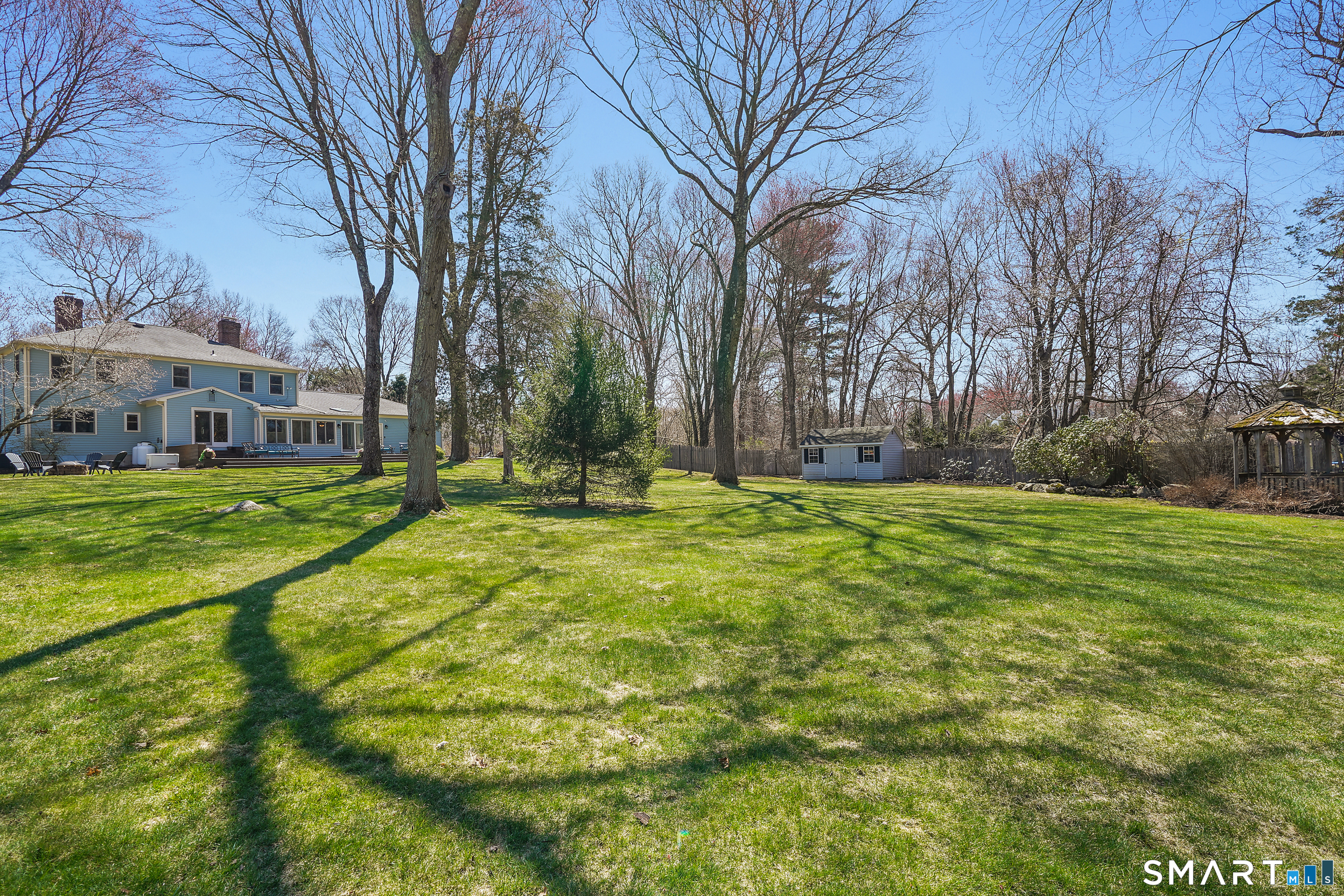 21 Shawnee Lane Monroe, CT 06468 - Photo 3 of 39 a backyard of a house with large trees and outdoor seating