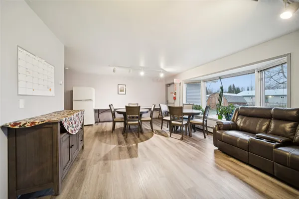 a living room with furniture a large window and wooden floor