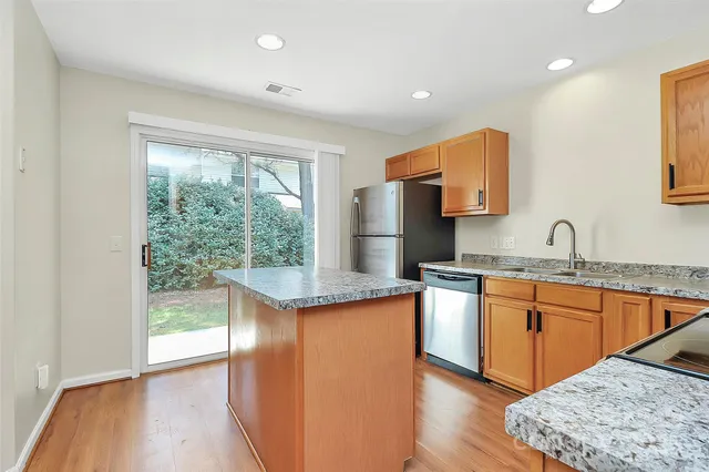 a kitchen with stainless steel appliances granite countertop a sink and wooden cabinets