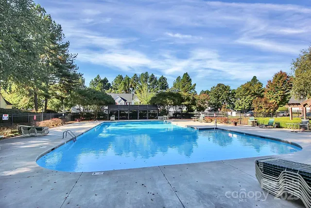 a view of swimming pool with outdoor seating and plants