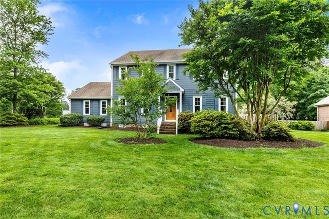 a front view of a house with a yard and trees