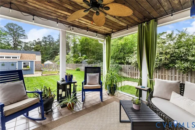 a view of a patio with table and chairs with wooden floor and fence