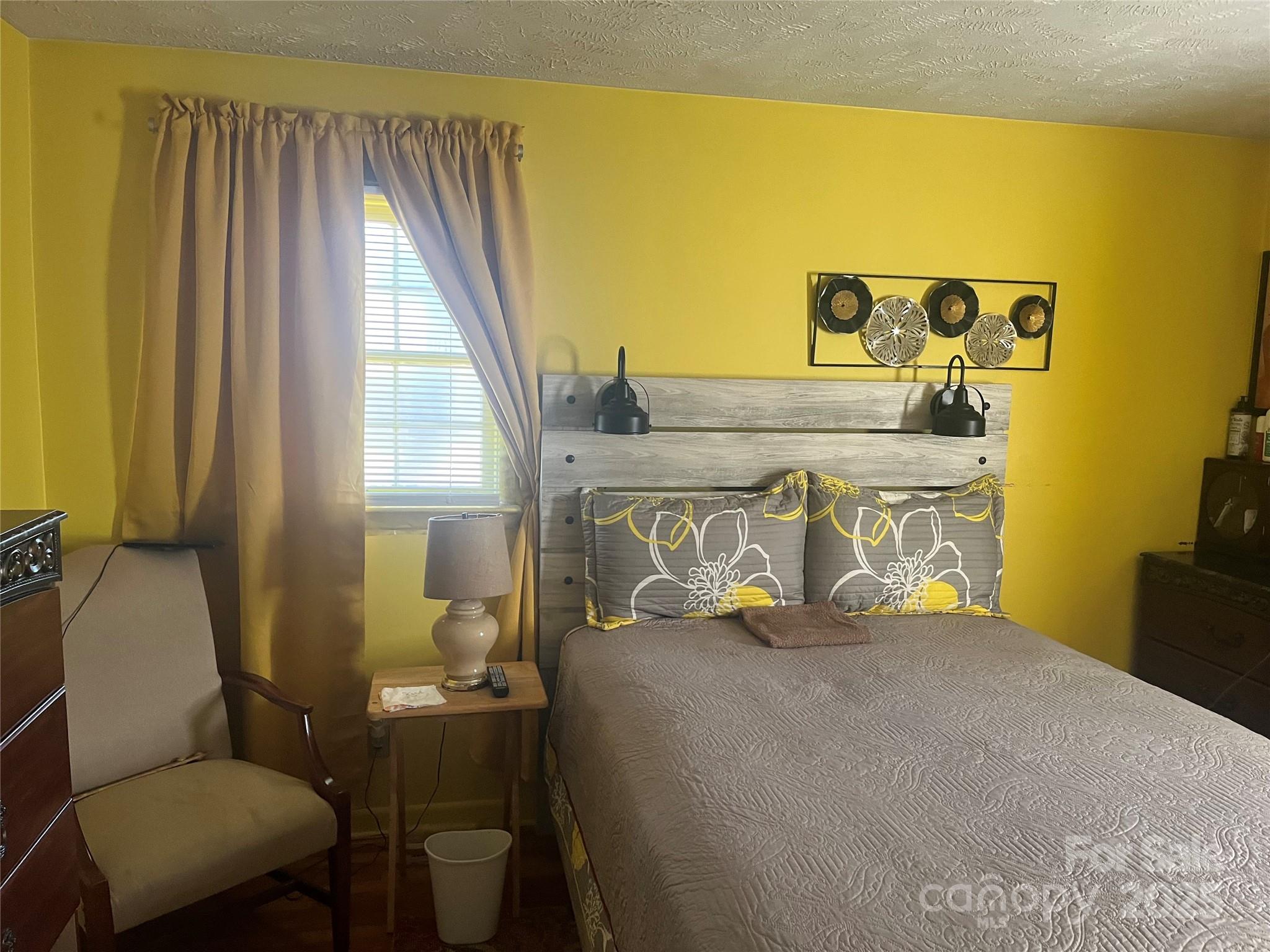 512 Produce Market Road Laurinburg, NC 28352 - Photo 7 of 10 a bedroom with a bed and wooden floor