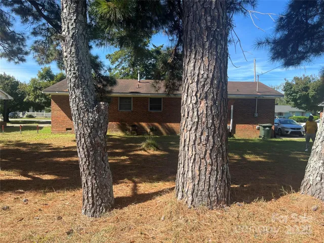 a view of a yard in front of a house with large tree