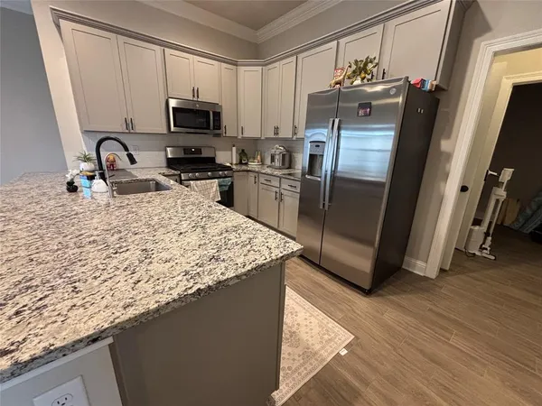 a kitchen with granite countertop a refrigerator and a sink