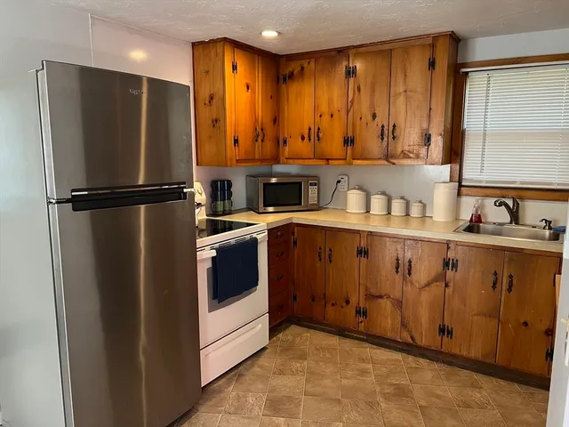 a kitchen with a refrigerator sink and cabinets