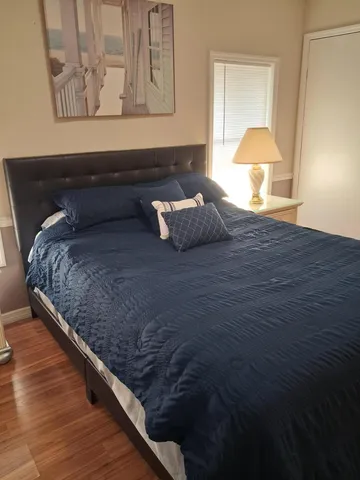 a bedroom with a bed and painting on the wall