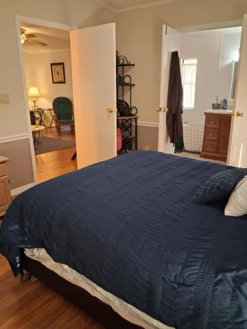 a bedroom with a bed and wooden floor