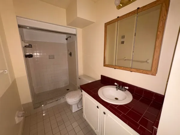 a bathroom with a granite countertop sink toilet and shower