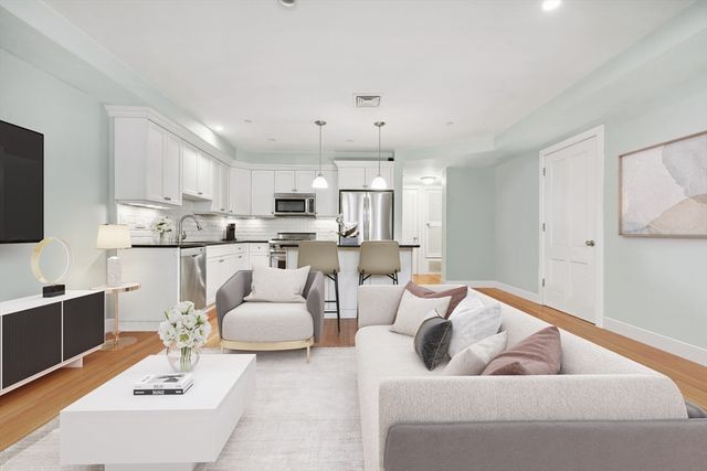 a living room with furniture and kitchen view