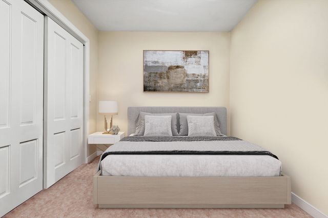 a large bed sitting in a bedroom next to a window