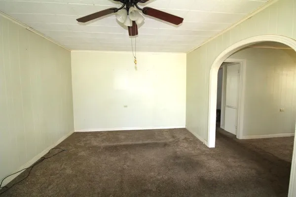 an empty room with a ceiling fan and a window