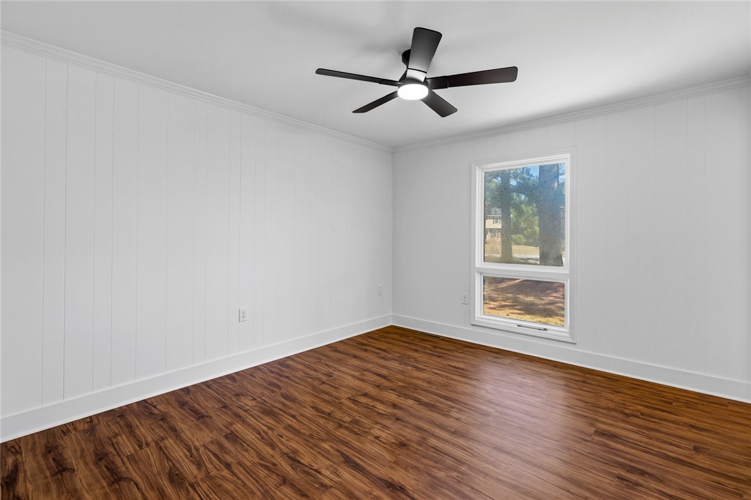 208 Williamsburg Road Anderson, SC 29621 - Photo 27 of 48 Rich wood-look flooring and textured paneling complement a window overlooking mature trees.