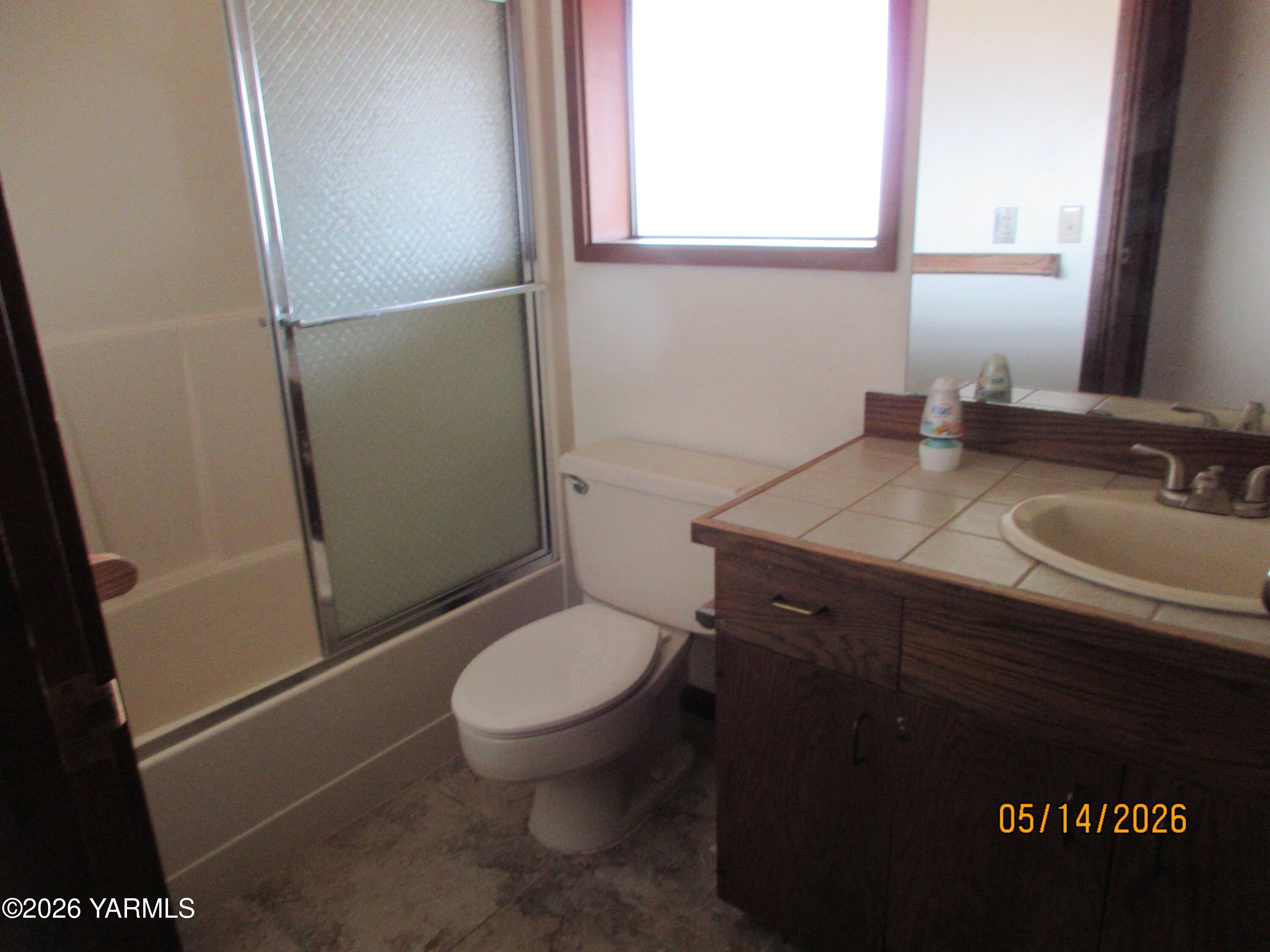 1303 Nightingale Road Wapato, WA 98951 - Photo 11 of 26 a bathroom with a granite countertop toilet sink and mirror