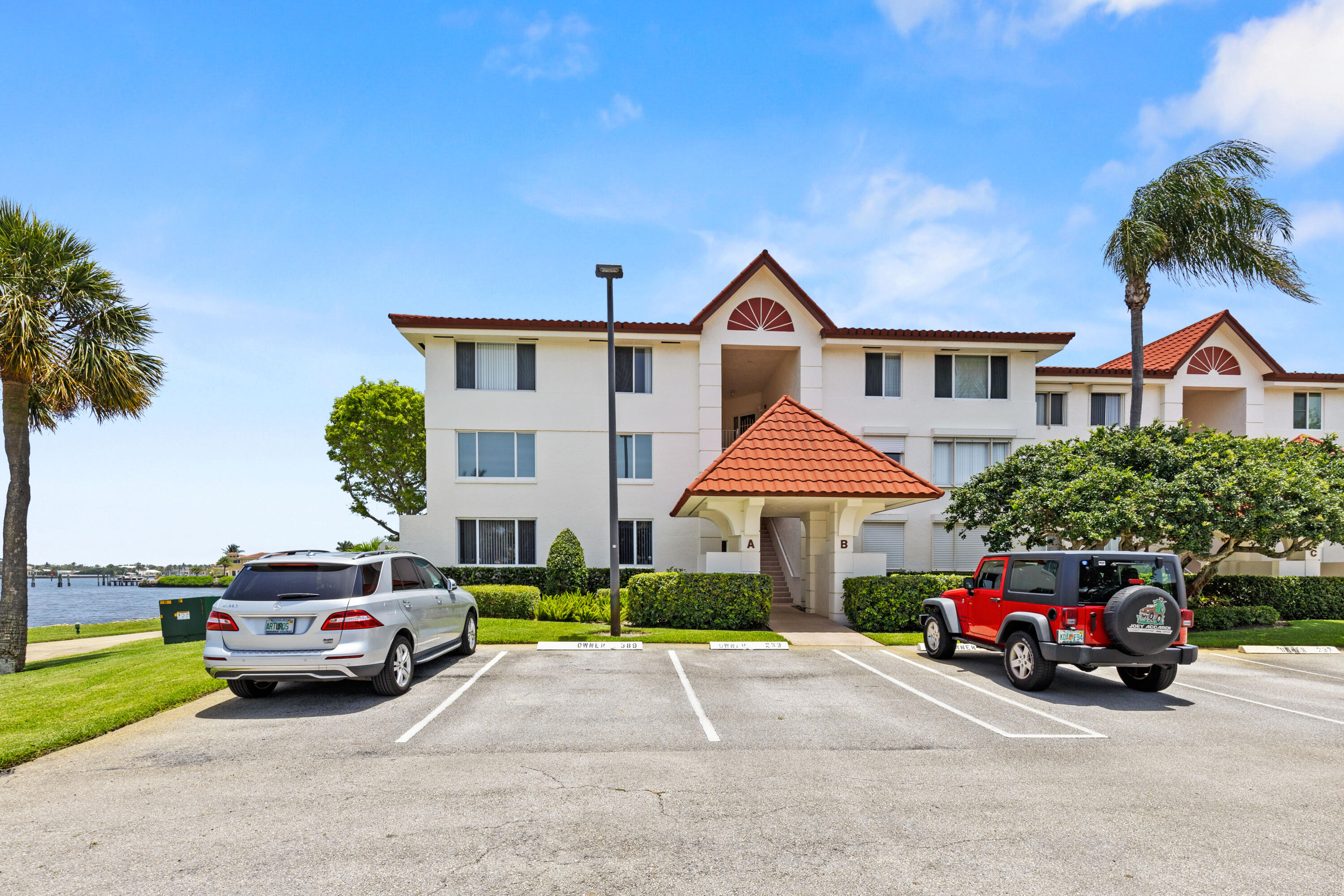 109 Half Moon Circle, Unit A3 Hypoluxo, FL 33462 - Photo 16 of 20 a car parked in front of a house with a yard