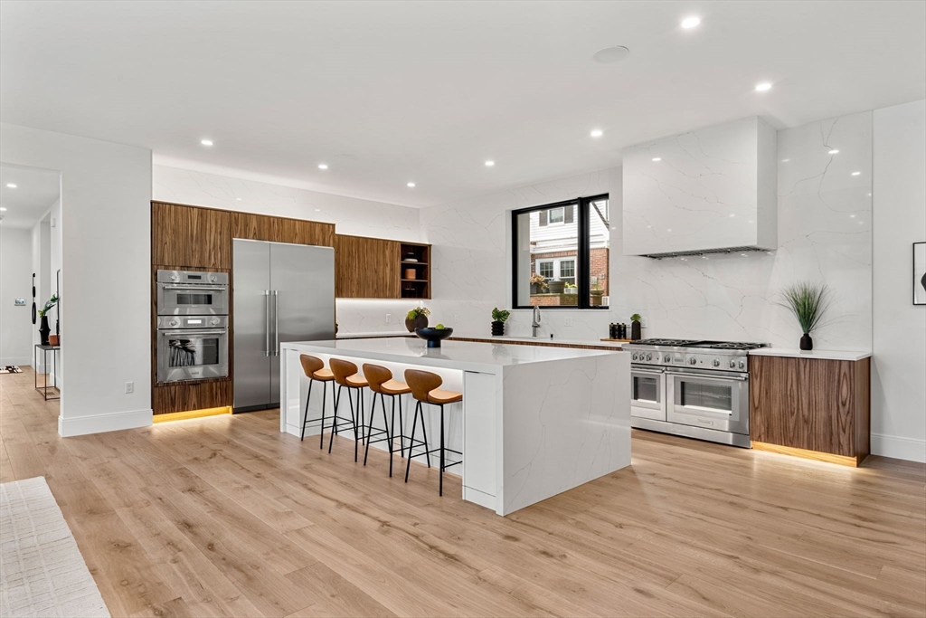 17 Prospect Hill Road Lexington, MA 02421 - Photo 14 of 42 a kitchen with stainless steel appliances kitchen island granite countertop a refrigerator a stove top oven and a wooden floors